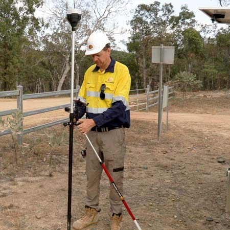 Surveyor standing next to survery pole with bipod attached